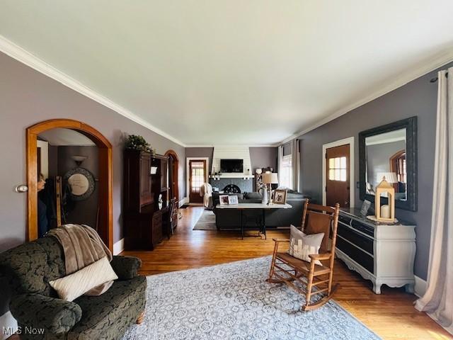 161 W Main St, New Concord, OH 43762 - living area with crown molding, light wood-style floors, arched walkways, and baseboards