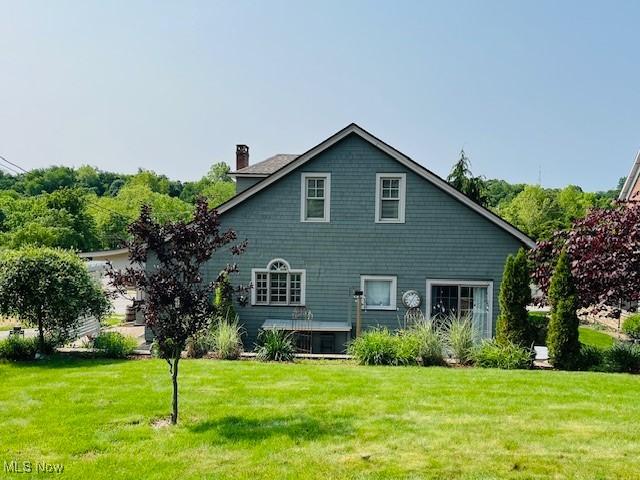 161 W Main St, New Concord, OH 43762 - back of house featuring a chimney and a yard