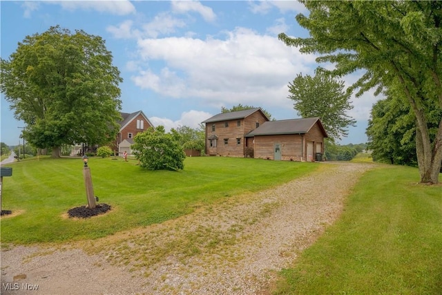 6165 Tyro St NE, Louisville, OH 44641 - view of green lawn featuring driveway and an outbuilding