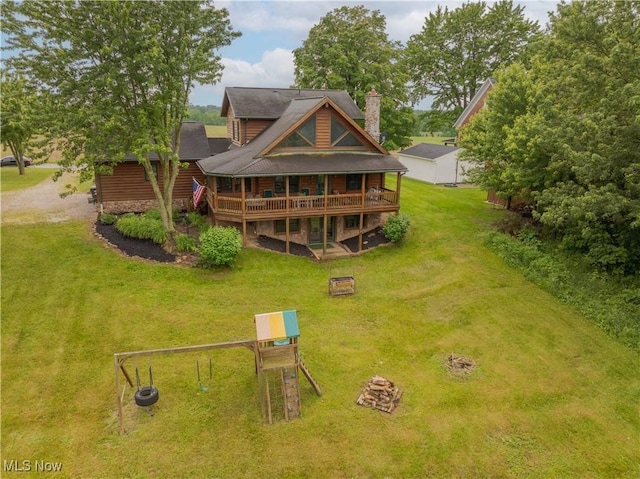 6165 Tyro St NE, Louisville, OH 44641 - rear view of house featuring a lawn, an outdoor fire pit, a wooden deck, and a chimney