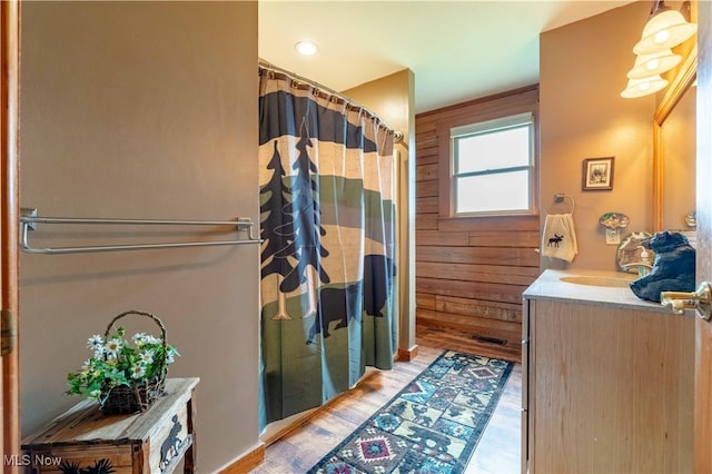 6165 Tyro St NE, Louisville, OH 44641 - bathroom featuring wooden walls, a shower with curtain, vanity, and wood finished floors