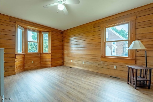 6165 Tyro St NE, Louisville, OH 44641 - empty room with plenty of natural light, wood finished floors, ceiling fan, and wood walls