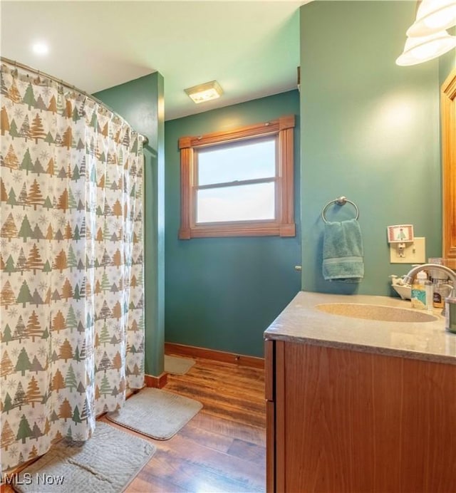 6165 Tyro St NE, Louisville, OH 44641 - bathroom featuring vanity, wood finished floors, curtained shower, and baseboards