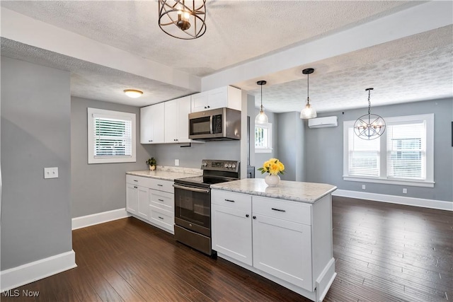 990 Franklin Ave, Salem, OH 44460 - kitchen with appliances with stainless steel finishes, a textured ceiling, an AC wall unit, baseboards, and a chandelier