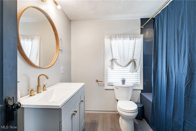990 Franklin Ave, Salem, OH 44460 - bathroom featuring vanity, wood finished floors, toilet, shower / tub combo with curtain, and a textured ceiling