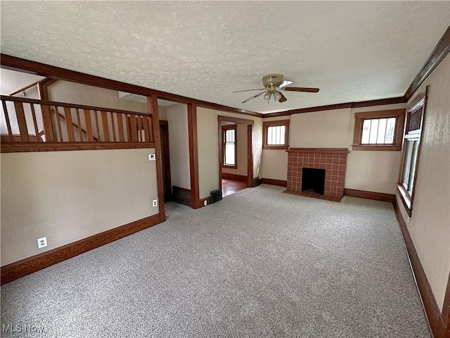 816 Clarendon Ave NW, Canton, OH 44708 - unfurnished living room featuring ceiling fan, light colored carpet, a fireplace, a textured ceiling, and baseboards