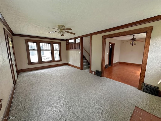 816 Clarendon Ave NW, Canton, OH 44708 - carpeted empty room with ceiling fan, stairway, baseboards, a textured ceiling, and crown molding