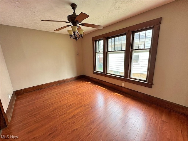816 Clarendon Ave NW, Canton, OH 44708 - unfurnished room with baseboards, plenty of natural light, wood finished floors, a textured ceiling, and ceiling fan