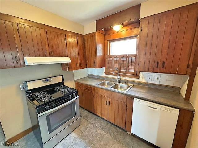 816 Clarendon Ave NW, Canton, OH 44708 - kitchen with white dishwasher, gas stove, under cabinet range hood, a sink, and decorative backsplash