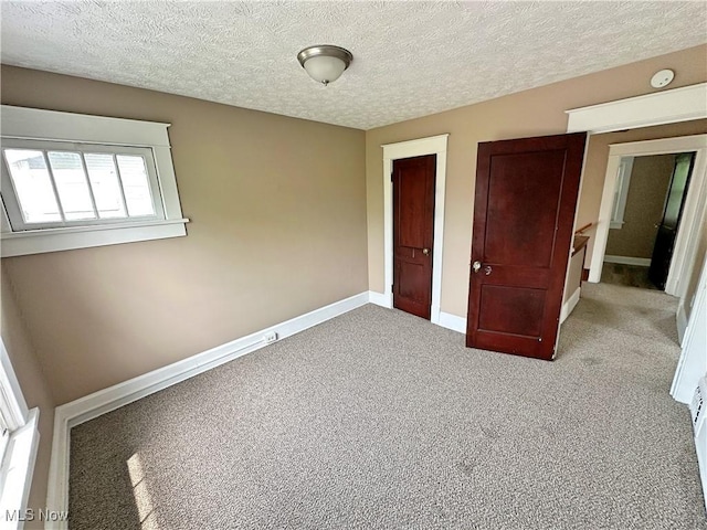 816 Clarendon Ave NW, Canton, OH 44708 - unfurnished bedroom featuring carpet, a textured ceiling, a closet, and baseboards
