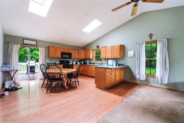 51406 Cornerstone Dr, Petersburg, OH 44454 - kitchen with a skylight, black microwave, light wood-type flooring, high vaulted ceiling, and a peninsula