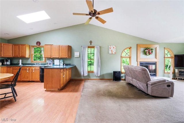 51406 Cornerstone Dr, Petersburg, OH 44454 - kitchen featuring open floor plan, a peninsula, a glass covered fireplace, light wood-type flooring, and a ceiling fan