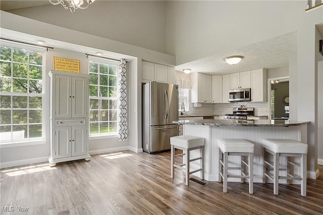 269 Brookledge Ln, Copley, OH 44321 - kitchen with appliances with stainless steel finishes, baseboards, dark stone countertops, tasteful backsplash, and white cabinets