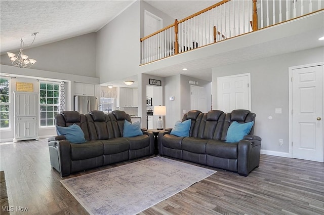 269 Brookledge Ln, Copley, OH 44321 - living area with high vaulted ceiling, a chandelier, wood finished floors, baseboards, and a textured ceiling