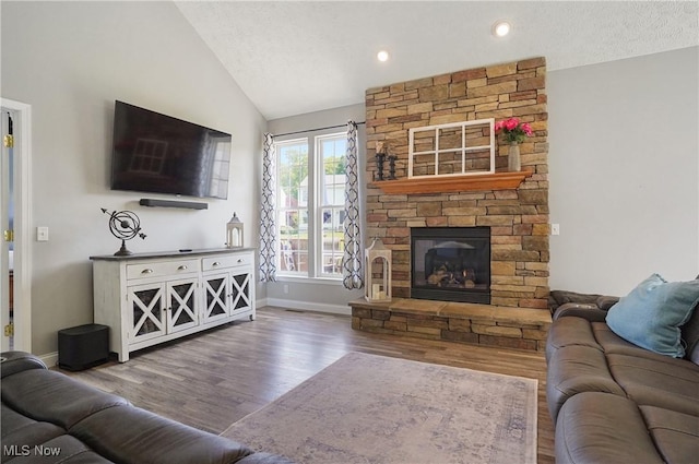 269 Brookledge Ln, Copley, OH 44321 - living room featuring wood finished floors, lofted ceiling, a fireplace, baseboards, and recessed lighting