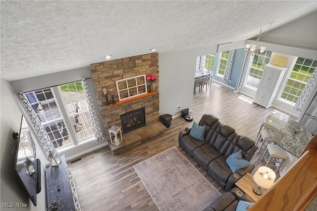 269 Brookledge Ln, Copley, OH 44321 - living area featuring a textured ceiling, baseboards, wood finished floors, a stone fireplace, and recessed lighting