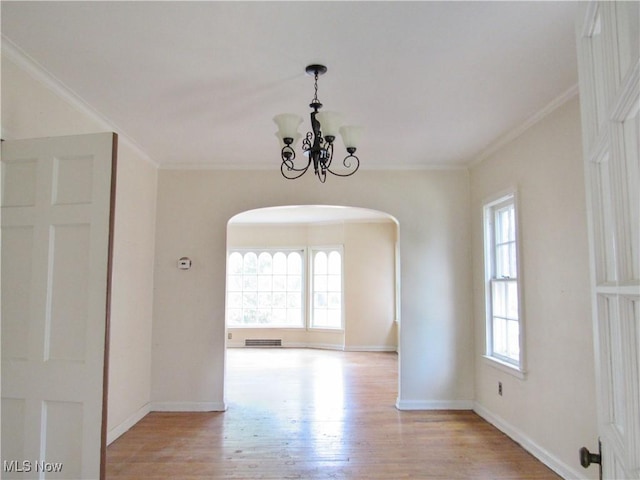 3659 Riedham Rd, Shaker Heights, OH 44120 - spare room featuring arched walkways, light wood-style floors, a chandelier, ornamental molding, and baseboards