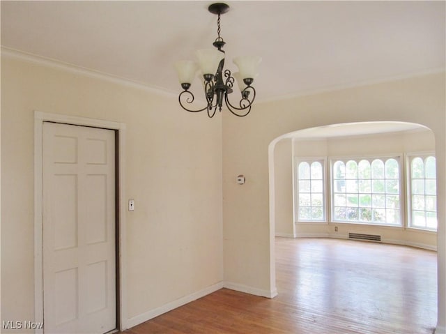 3659 Riedham Rd, Shaker Heights, OH 44120 - spare room featuring arched walkways, wood finished floors, a chandelier, baseboards, and ornamental molding
