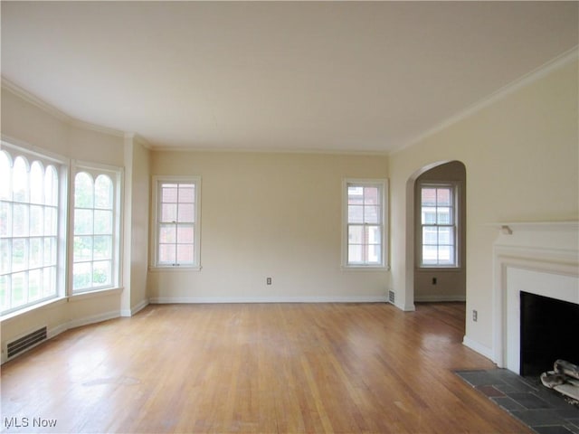 3659 Riedham Rd, Shaker Heights, OH 44120 - unfurnished living room with light wood finished floors, a fireplace with flush hearth, arched walkways, crown molding, and baseboards