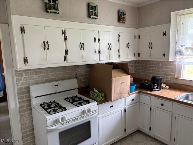 181 5th St NE, Carrollton, OH 44615 - kitchen featuring white range with gas stovetop, tasteful backsplash, white cabinetry, and light countertops