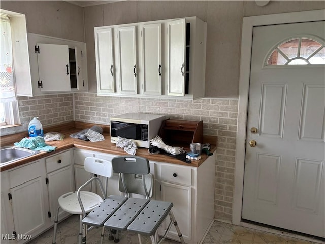 181 5th St NE, Carrollton, OH 44615 - kitchen featuring white microwave, white cabinetry, butcher block countertops, and a sink