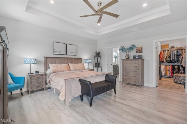 34655 N Legends Way, Grafton, OH 44044 - bedroom with a raised ceiling, light wood-type flooring, a spacious closet, recessed lighting, and connected bathroom