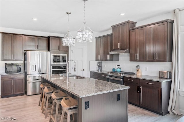 34655 N Legends Way, Grafton, OH 44044 - kitchen with appliances with stainless steel finishes, under cabinet range hood, light wood-style floors, light stone countertops, and recessed lighting
