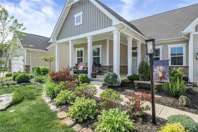 34655 N Legends Way, Grafton, OH 44044 - view of front of property with board and batten siding, stone siding, a porch, and roof with shingles