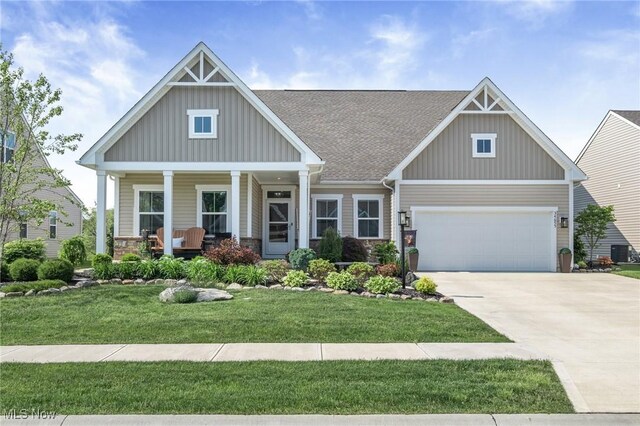 34655 N Legends Way, Grafton, OH 44044 - craftsman-style home featuring board and batten siding, driveway, an attached garage, a porch, and stone siding