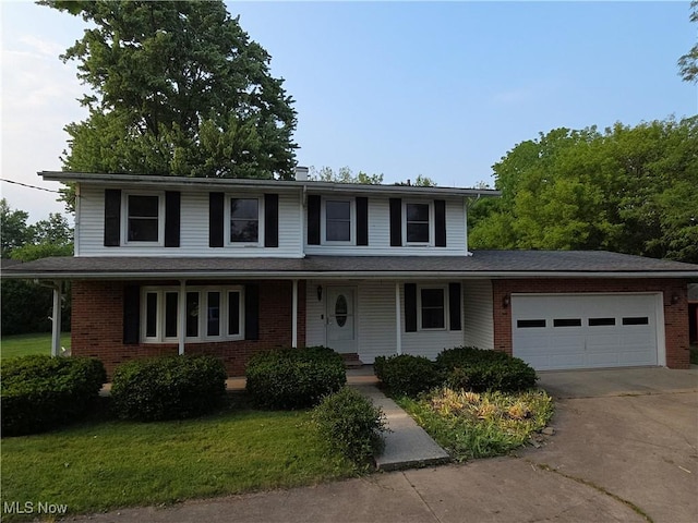 1025 S Ridge Rd, Geneva, OH 44041 - view of front of house featuring driveway, covered porch, an attached garage, and brick siding