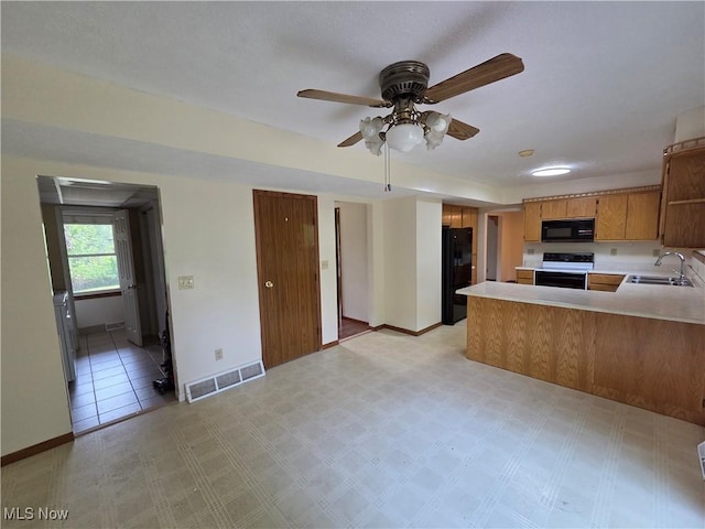 1025 S Ridge Rd, Geneva, OH 44041 - kitchen featuring black appliances, a sink, light countertops, and a peninsula