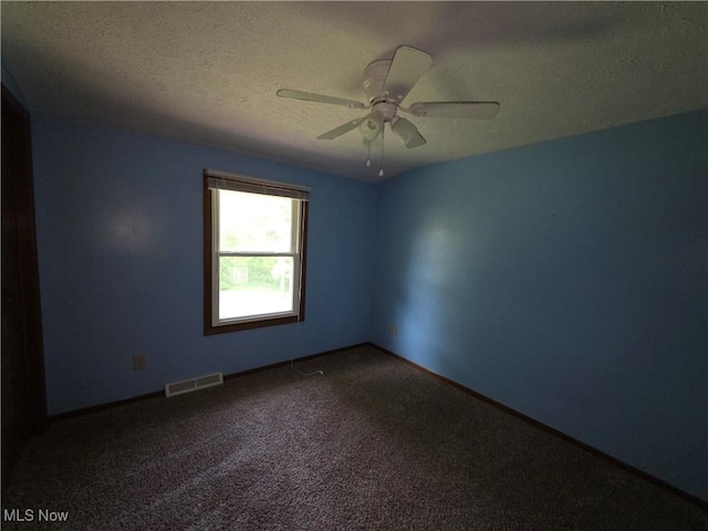 1025 S Ridge Rd, Geneva, OH 44041 - spare room featuring a textured ceiling, dark carpet, ceiling fan, and baseboards