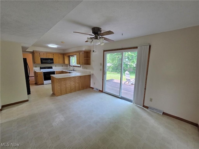 1025 S Ridge Rd, Geneva, OH 44041 - kitchen with a sink, black appliances, a peninsula, light countertops, and baseboards