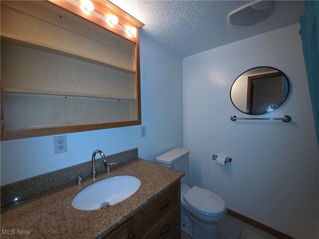 1025 S Ridge Rd, Geneva, OH 44041 - bathroom featuring toilet, a textured ceiling, vanity, and tile patterned flooring
