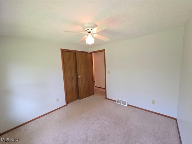 1025 S Ridge Rd, Geneva, OH 44041 - unfurnished bedroom featuring light colored carpet, a closet, baseboards, and a ceiling fan