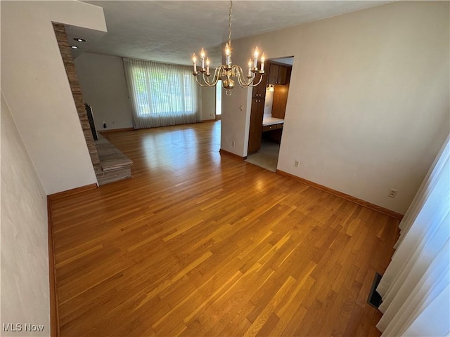 158 Main St, Rayland, OH 43943 - unfurnished dining area with a chandelier, baseboards, and light wood-type flooring