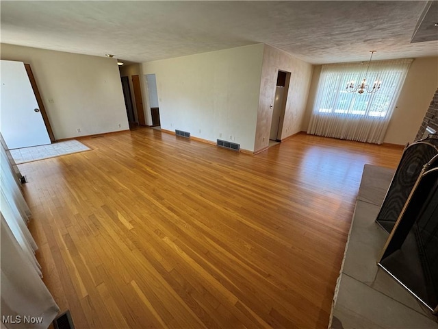 158 Main St, Rayland, OH 43943 - unfurnished living room featuring a chandelier, light wood-type flooring, and baseboards