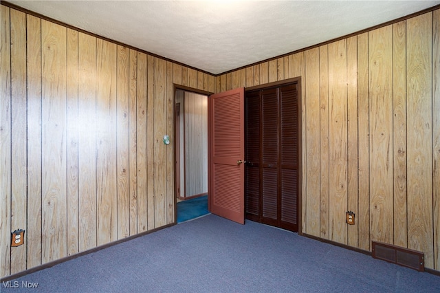 4855 Lake Dawn Dr, Medina, OH 44256 - unfurnished bedroom featuring a closet, carpet flooring, wooden walls, and a textured ceiling