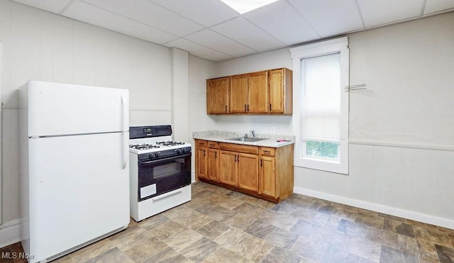369 Cuyahoga St, Akron, OH 44310 - kitchen with white appliances, a sink, a paneled ceiling, light countertops, and brown cabinetry