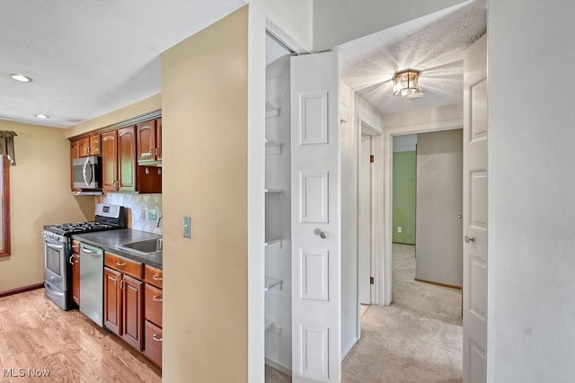 2610 Norton Rd, Stow, OH 44224 - kitchen with appliances with stainless steel finishes, dark countertops, decorative backsplash, baseboards, and a sink