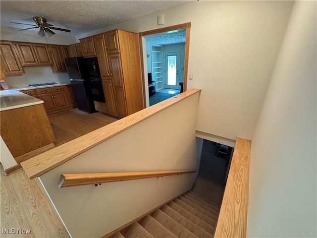 11025 Henning Dr, Chardon, OH 44024 - stairway with wood finished floors, a ceiling fan, and a textured ceiling