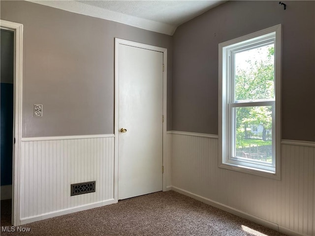 10919 Geib Ave NE, Hartville, OH 44632 - unfurnished bedroom with wainscoting, multiple windows, and carpet floors