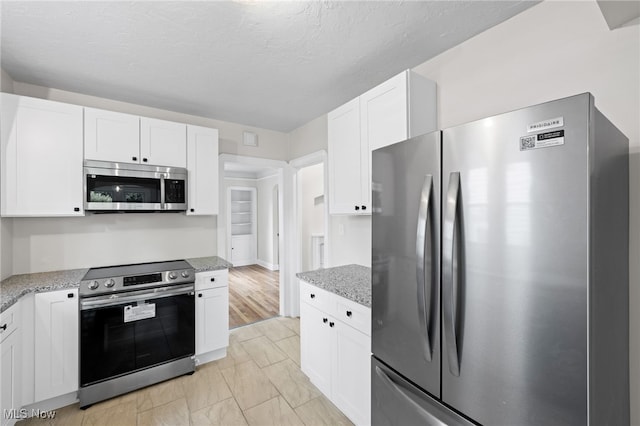 3497 Raymont Blvd, University Heights, OH 44118 - kitchen featuring appliances with stainless steel finishes, white cabinetry, and light stone countertops