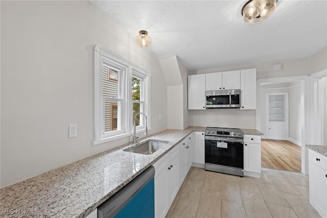 3497 Raymont Blvd, University Heights, OH 44118 - kitchen featuring appliances with stainless steel finishes, a sink, light stone countertops, and white cabinets