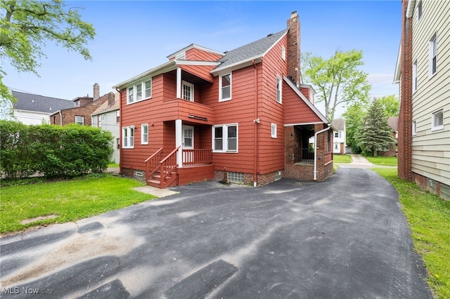 3497 Raymont Blvd, University Heights, OH 44118 - view of front of house with a chimney, asphalt driveway, and a front yard