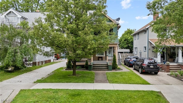 14520 Bayes Ave, Lakewood, OH 44107 - view of front facade featuring a porch, a front lawn, and driveway