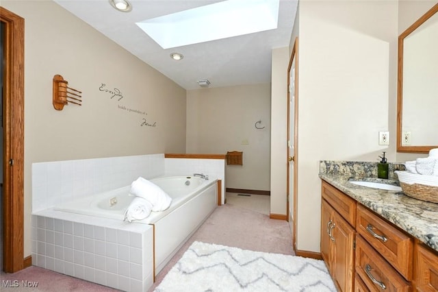 452 Herbert Rd, Akron, OH 44312 - full bathroom featuring a skylight, vanity, a garden tub, and baseboards