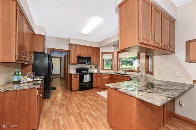 452 Herbert Rd, Akron, OH 44312 - kitchen with black appliances, a peninsula, light wood-style floors, tasteful backsplash, and brown cabinets