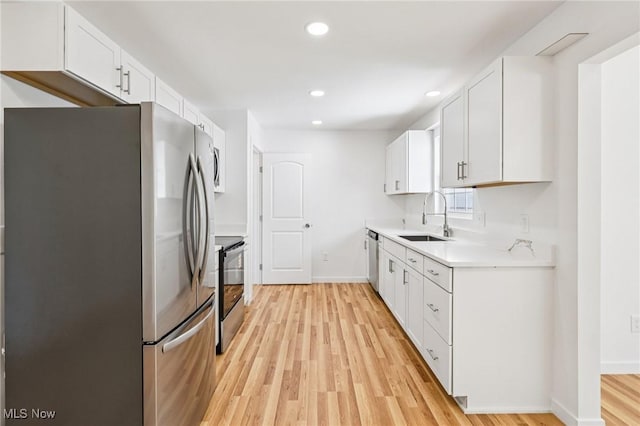 178 Lindsey Rd, Munroe Falls, OH 44262 - kitchen with stainless steel appliances, a sink, light wood-style flooring, light countertops, and white cabinets