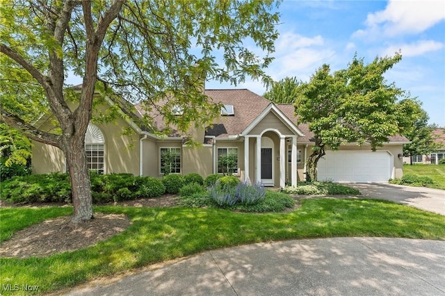 10378 N Pond Ln N Unit 2, Twinsburg, OH 44087 - view of front of home with stucco siding, driveway, an attached garage, and a front yard